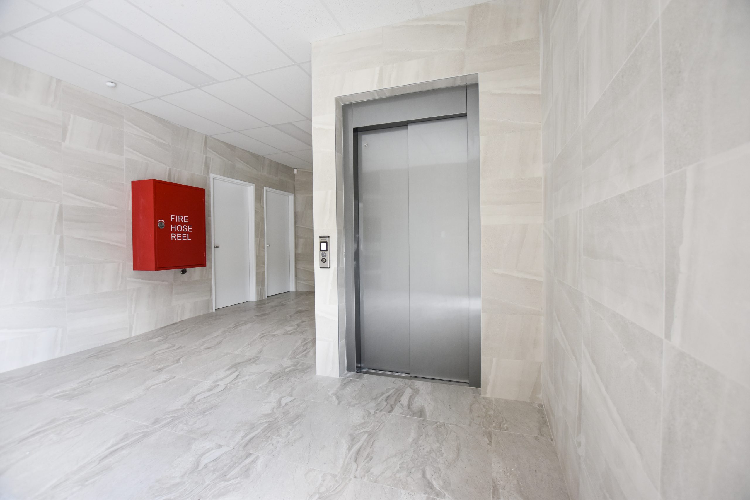 a closed door elevator in an apartment lobby.