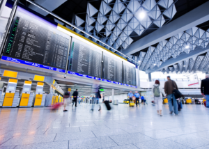 Busy airport terminal with departure boards.
