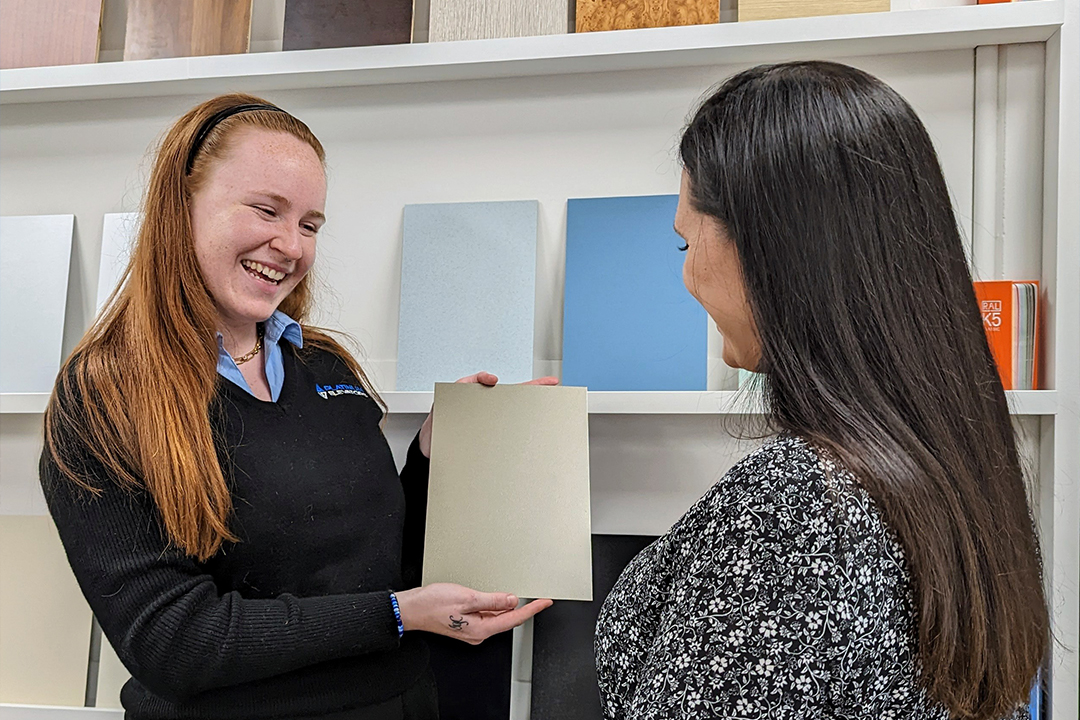Two women discussing colour samples in showroom.