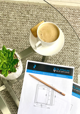 Coffee and elevator design plans on table.