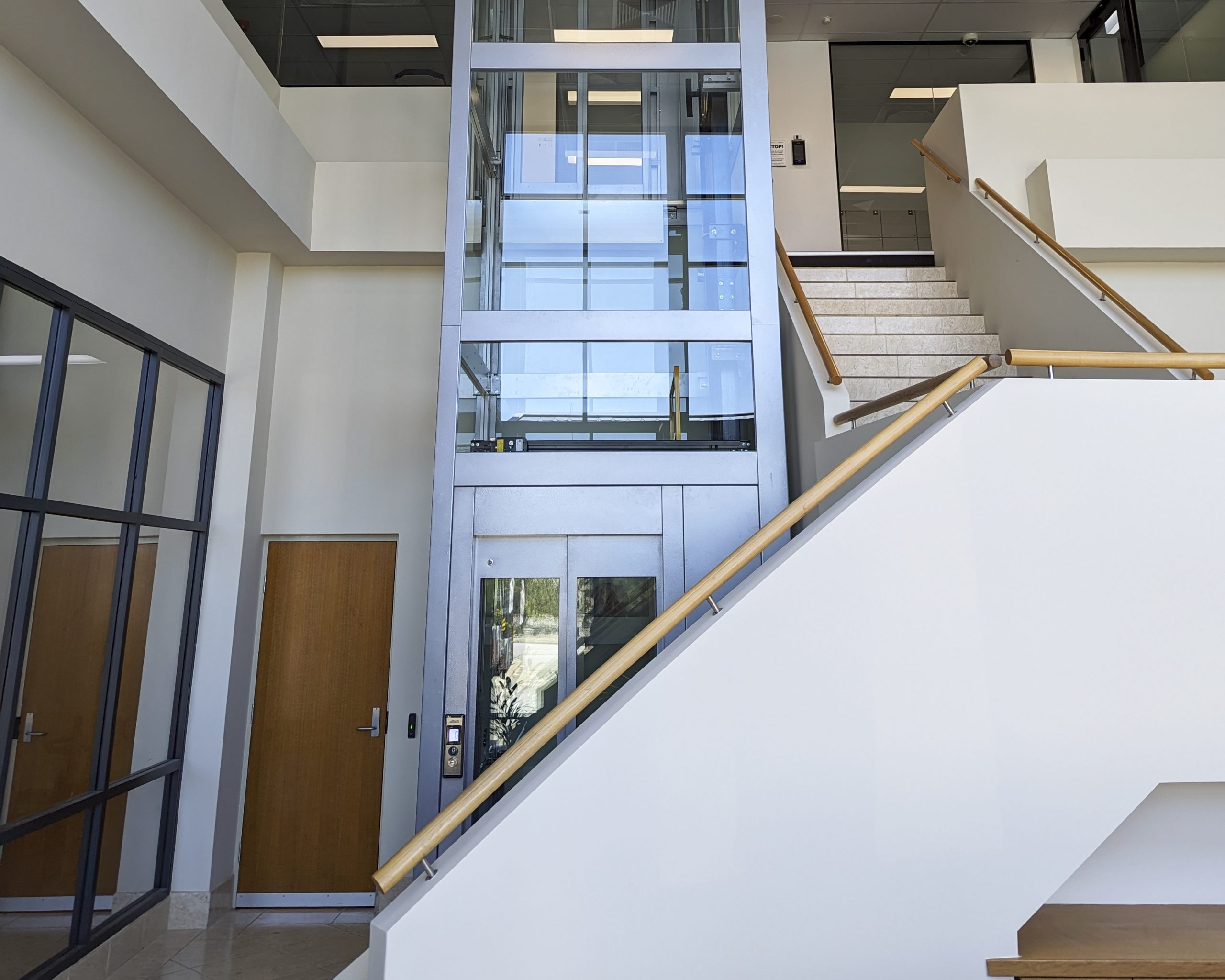 Modern office stairway and glass elevator.