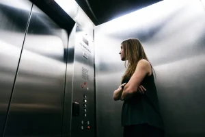 Person standing in elevator, looking at buttons.