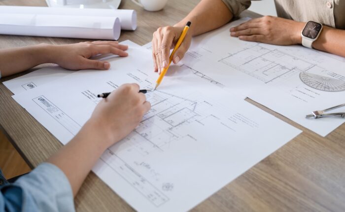 The Historical and Cultural Value of Heritage Homes People discussing architectural blueprints at table.