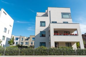 Modern apartment buildings with balconies and gardens.
