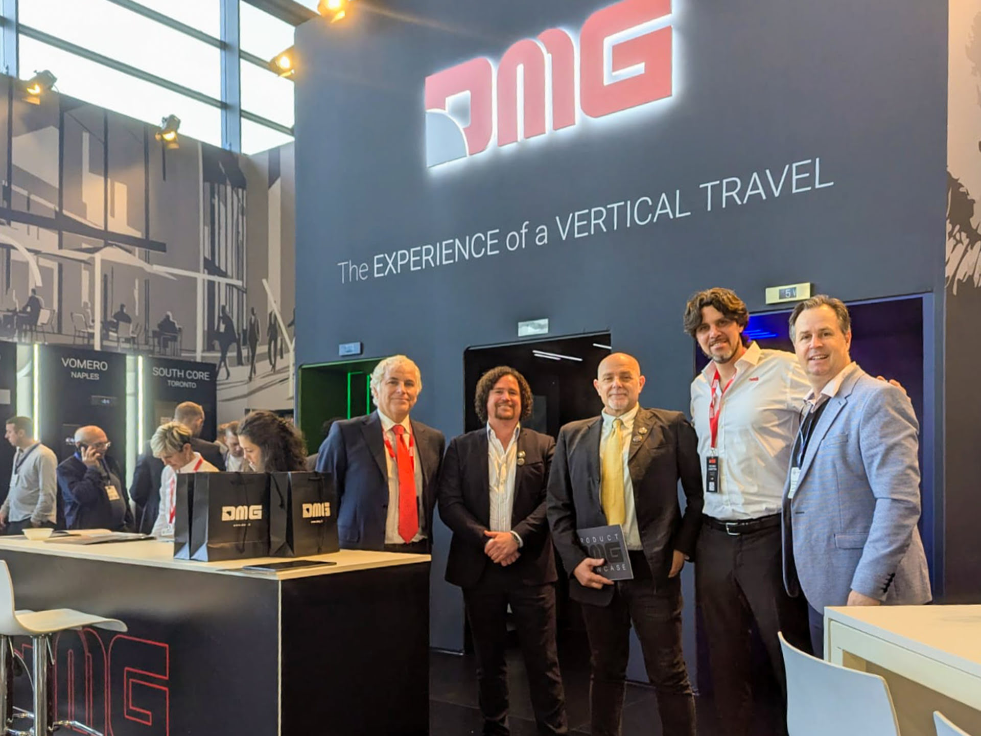 DMG exhibition booth with five people attending.