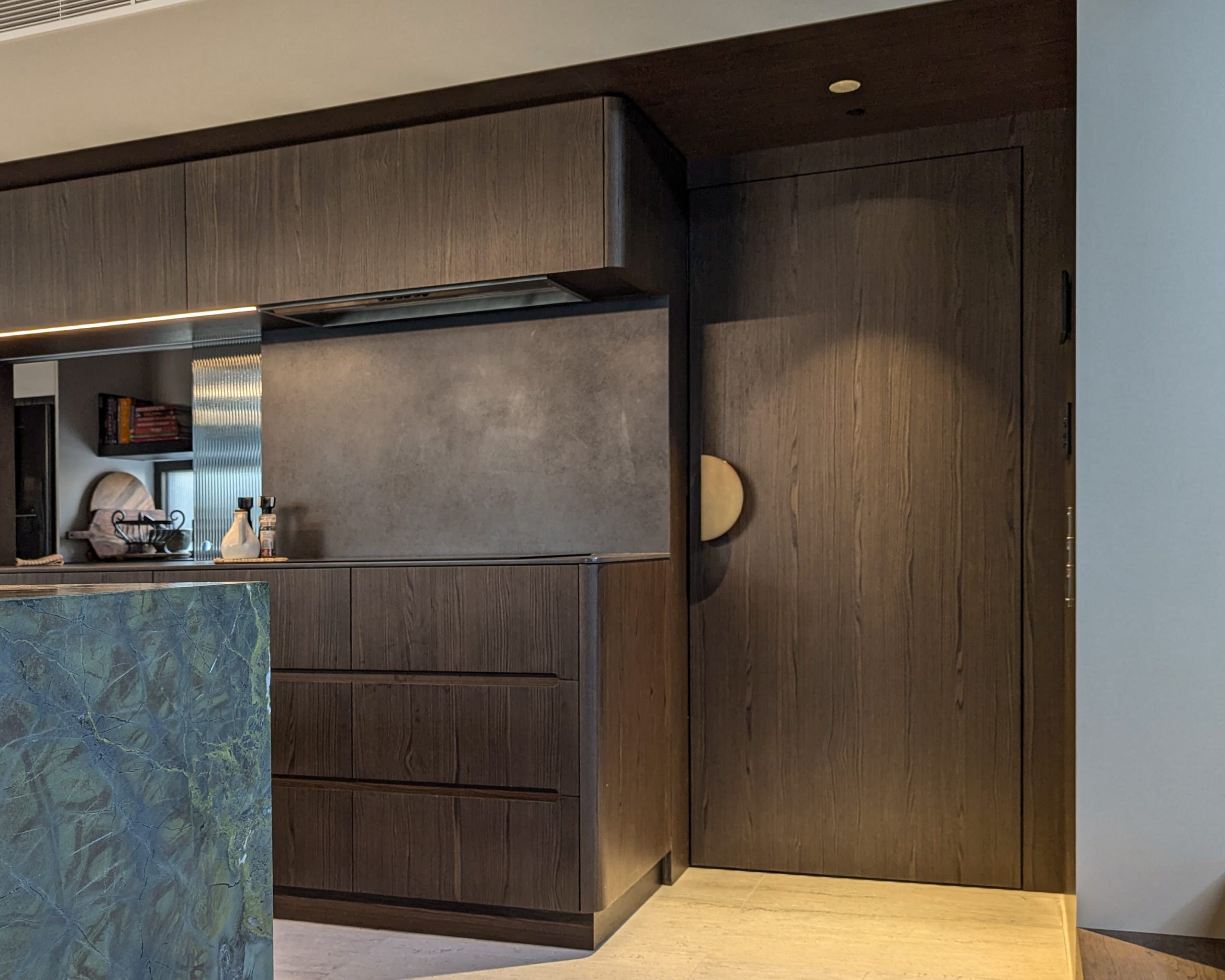 Modern kitchen with wooden cabinets and dark tones.