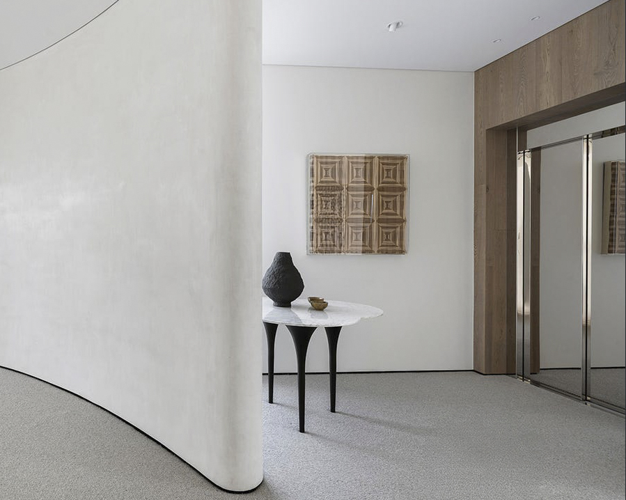 Modern minimalist interior with table and artwork.