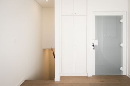Residential lift1 Minimalist residential lift next to staircase and frosted glass door