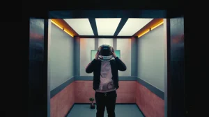 Raleigh Ritchie wearing spacesuit helmet in a elevator