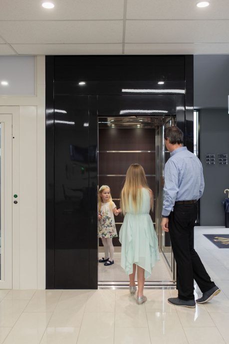 Family members at residential lift Family entering modern building lift together