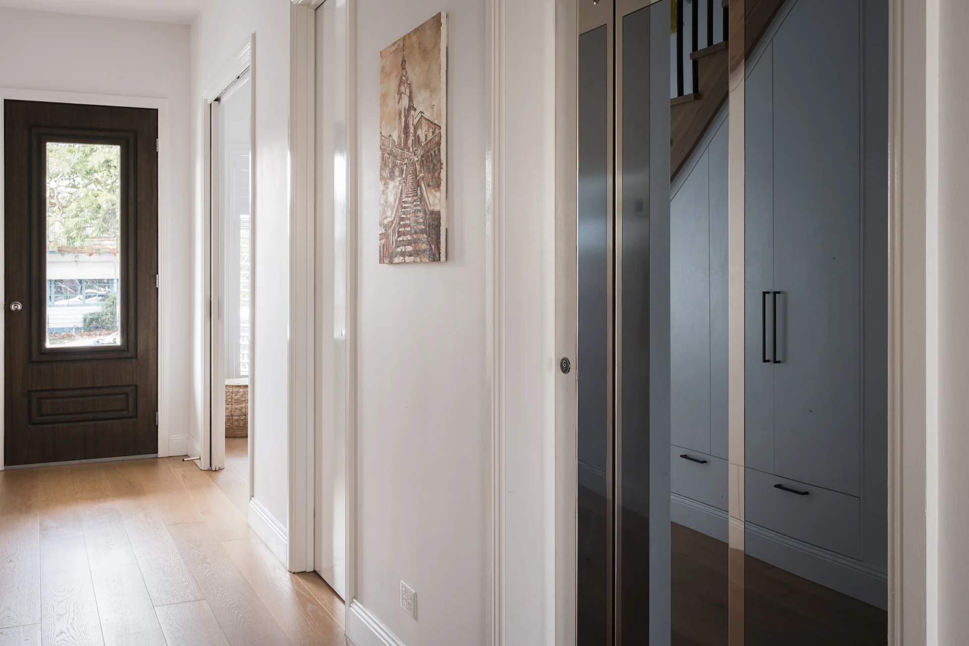Modern hallway with wooden floor and dark door