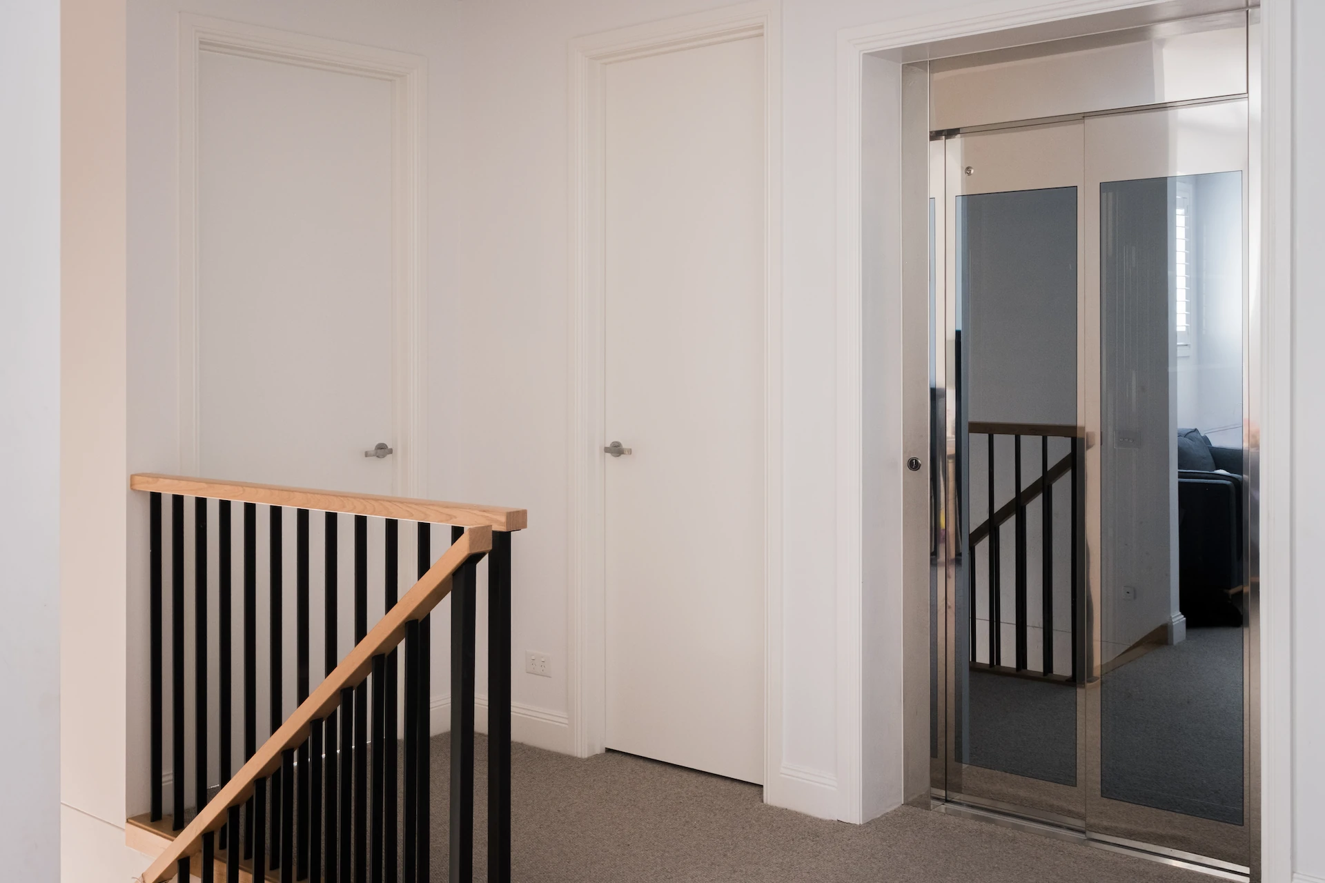 Hallway with white doors and reflective panel.