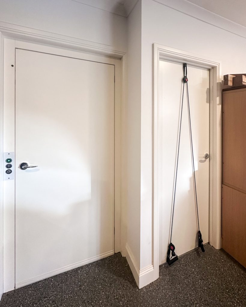 Resistance bands hanging over white interior door