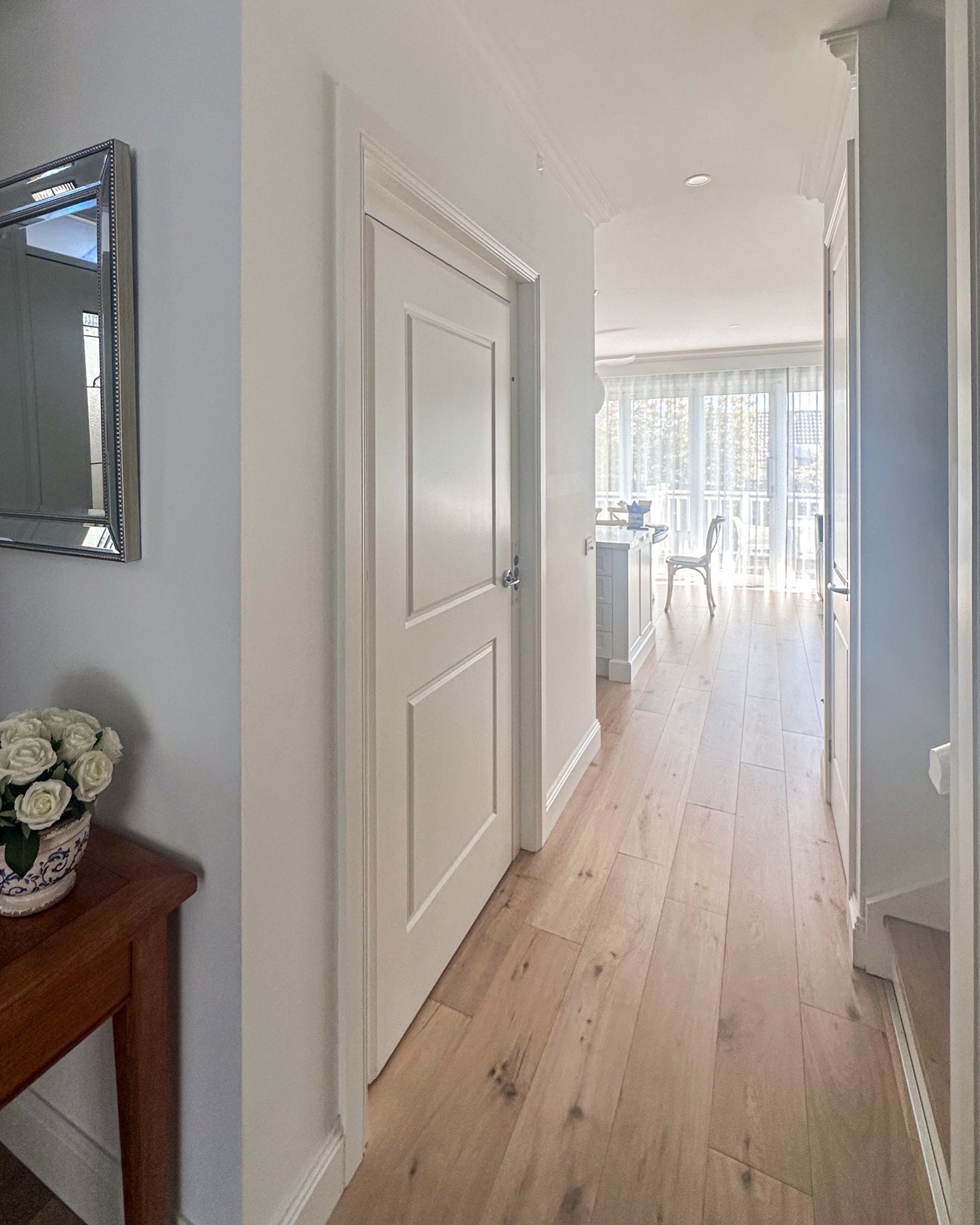 Bright hallway leading to sunlit dining area