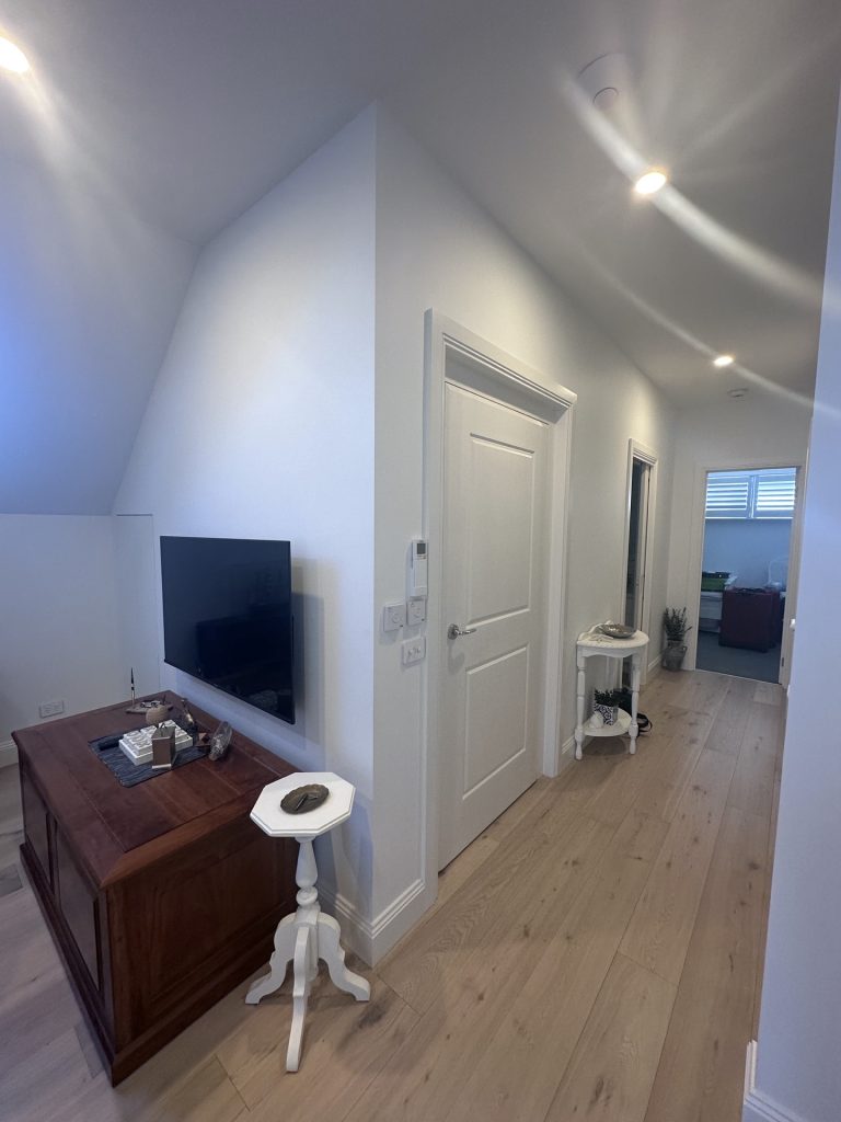 Modern hallway with timber floors and wall-mounted TV