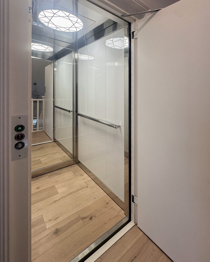 Modern residential lift with glass walls and timber floor
